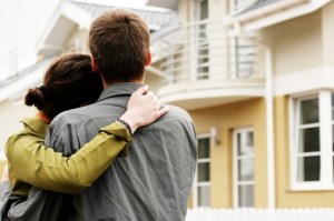 couple in  front of one-family house in modern residential area